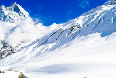 Low angle view of snowcapped mountains against sky