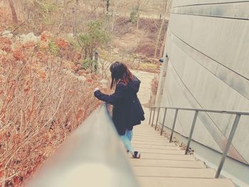 Side view of woman standing on staircase