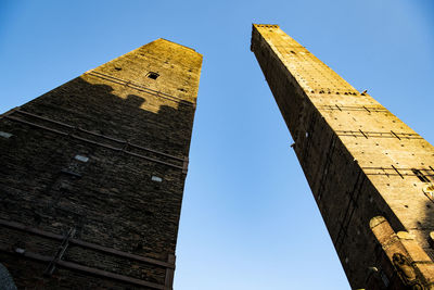 Low angle view of bologna two towers against clear blue sky