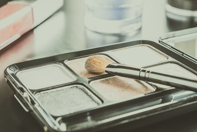 High angle view of brush on highlighter palette on table