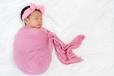 Cute baby girl lying on bed