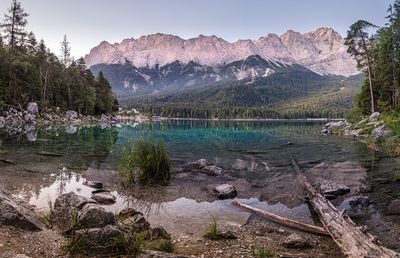 Scenic view of lake by mountains against sky