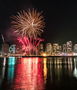 Firework display over river at night