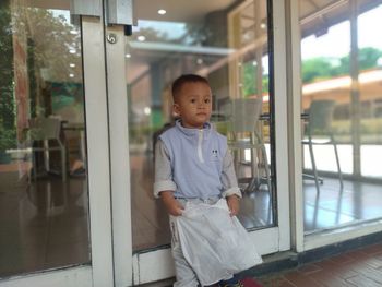 Portrait of boy looking through window