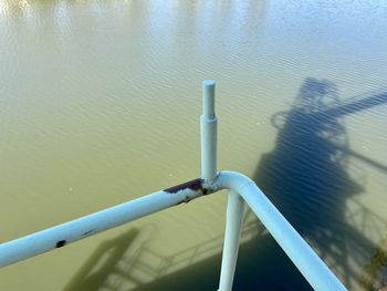 High angle view of metal railing by lake