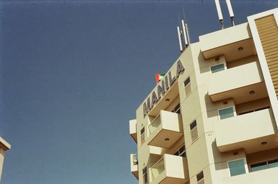 Low angle view of residential buildings against clear blue sky