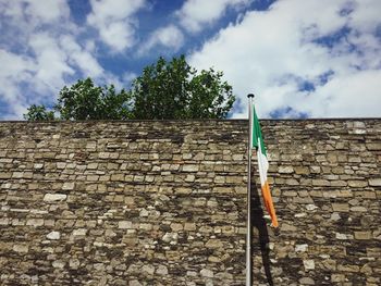 Low angle view of brick wall against sky