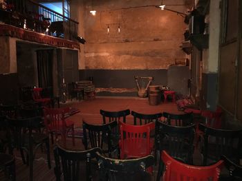 Empty chairs and tables in illuminated building