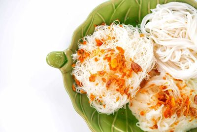 Close-up of pasta in plate against white background