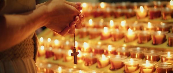 Cropped hand of person preparing candles