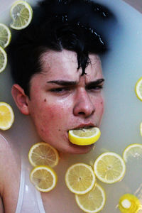 Directly above portrait of man with lemon slices in bathtub