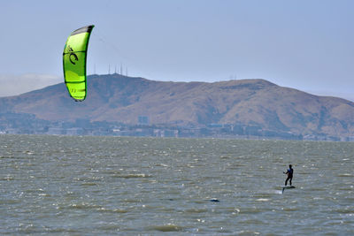 Man surfing in sea against sky