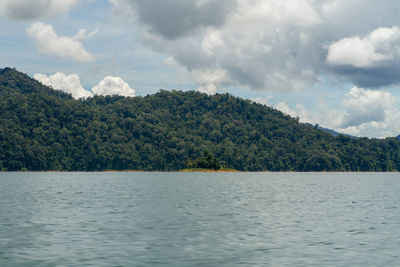 Scenic view of lake by trees against sky