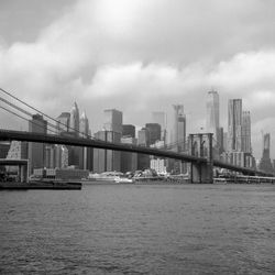 Bridge over river against cloudy sky