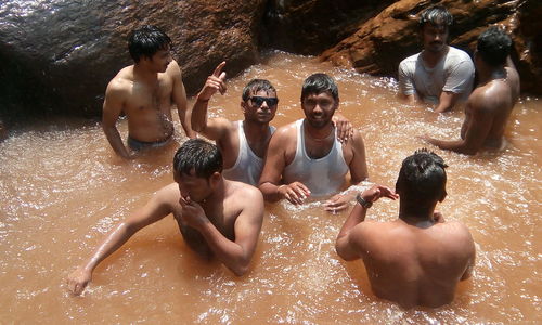 High angle view of men enjoying in pond