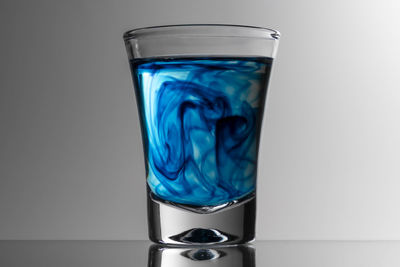 Close-up of blue glass against white background