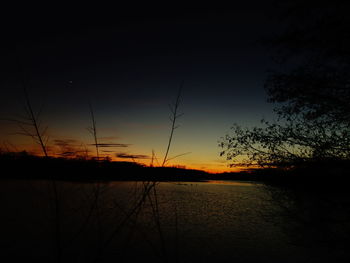 Scenic view of lake against sky at sunset