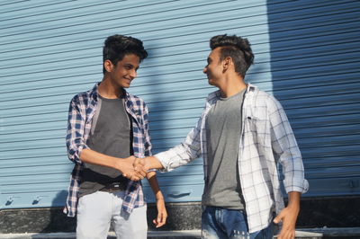 Side view of couple standing against wall