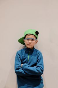 Portrait of man wearing sunglasses standing against gray background
