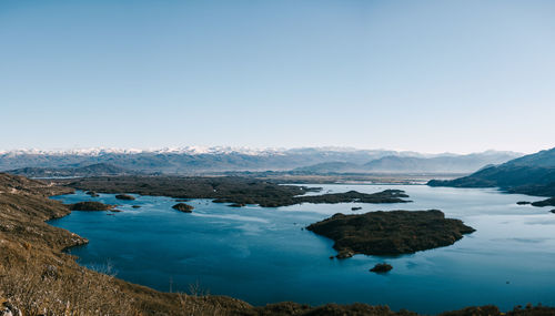 Scenic view of lake against clear blue sky