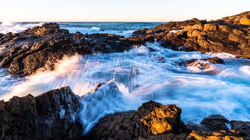 Panoramic view of waterfall through rocks against sky