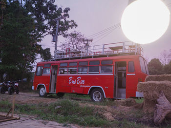 Red vintage car on street against sky