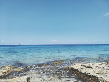 Scenic view of sea against blue sky during sunny day