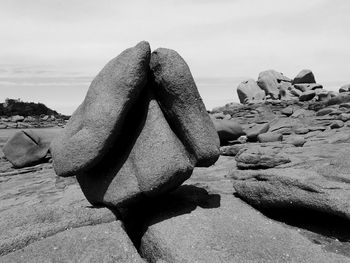 Rock formation on beach against sky