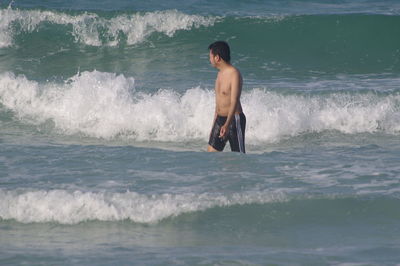 Full length of shirtless man in sea