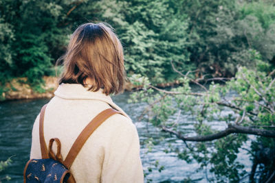 Woman standing against river in forest