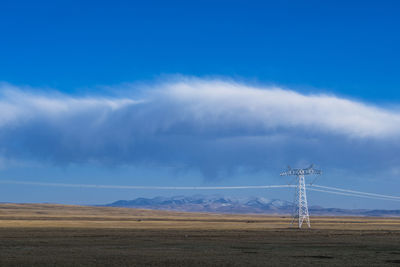 High voltage towers with sky background.