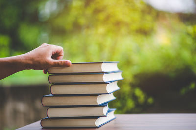 Person stacking books on table