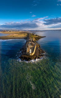 Scenic view of sea against sky with lighthouse