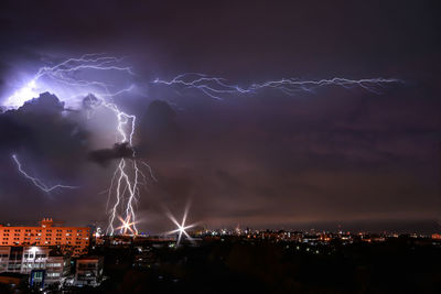 Forked lightning over city at night