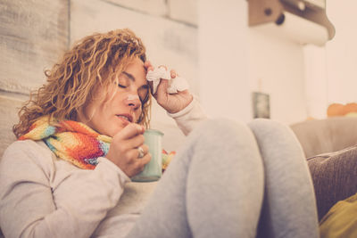 Young woman sitting on sofa at home