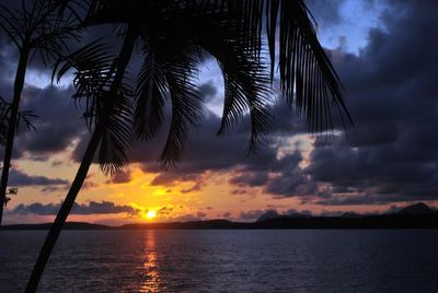 Scenic view of sea against cloudy sky at sunset