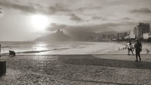 People walking on beach against sky