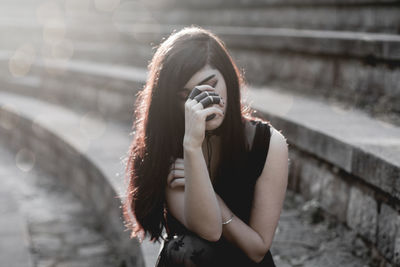 Portrait of young woman standing outdoors