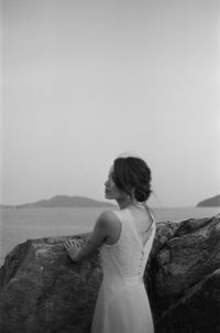 Bride standing at beach against sky