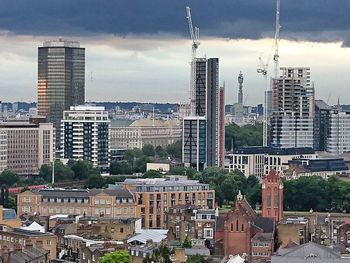 Buildings in city against cloudy sky