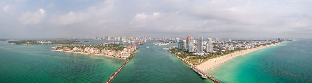 Panoramic view of sea and cityscape against sky