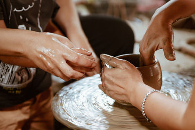 Midsection of man working on pottery wheel