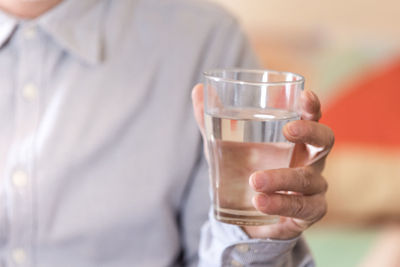 A glass of clean water or mineral water in man's hands. concept of environment protection.