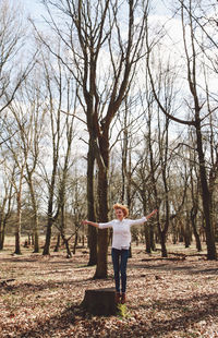 Full length of woman walking on bare tree