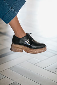 Low section of woman standing on tiled floor