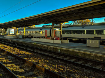 Train at railroad station against clear sky