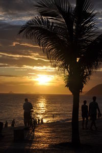 Silhouette people at beach during sunset