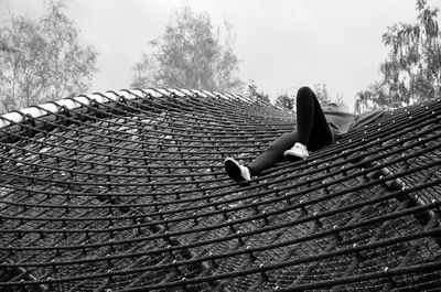 Girl sitting on floor against sky