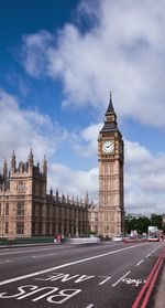 Clock tower in city against cloudy sky