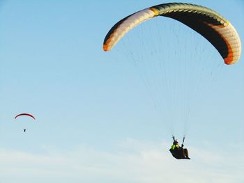 Low angle view of person paragliding against clear sky